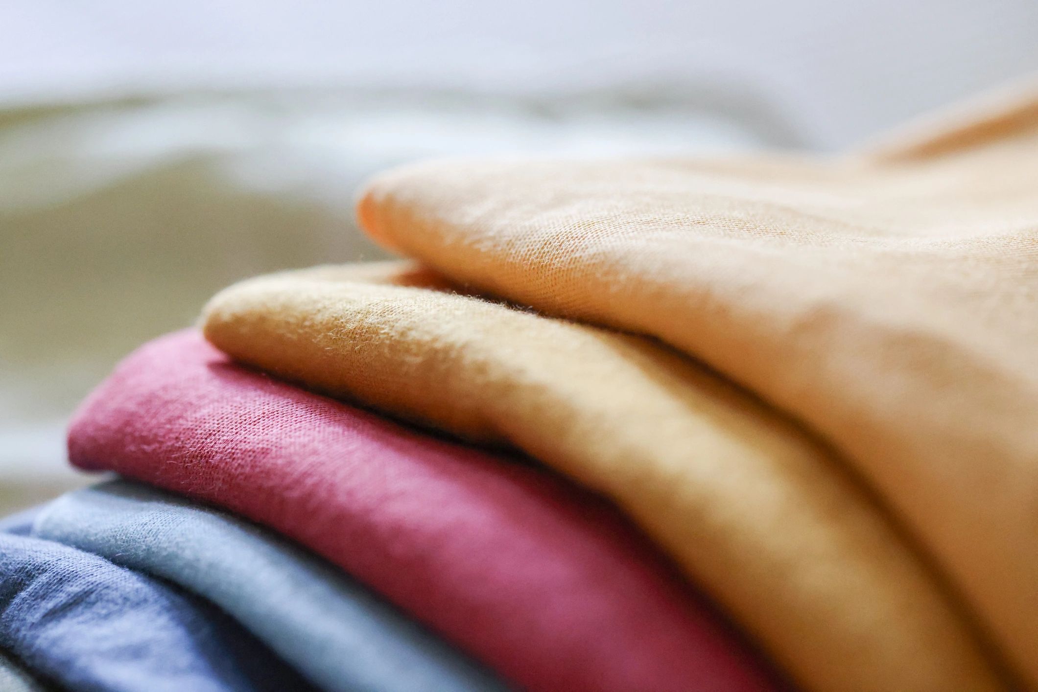 Folded clothing and quilted fabric on a bed